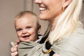 Mamma med barn i en bärsjal.