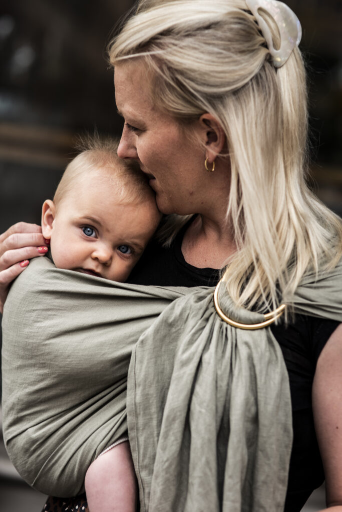 Mamma med barn i en bärsjal.